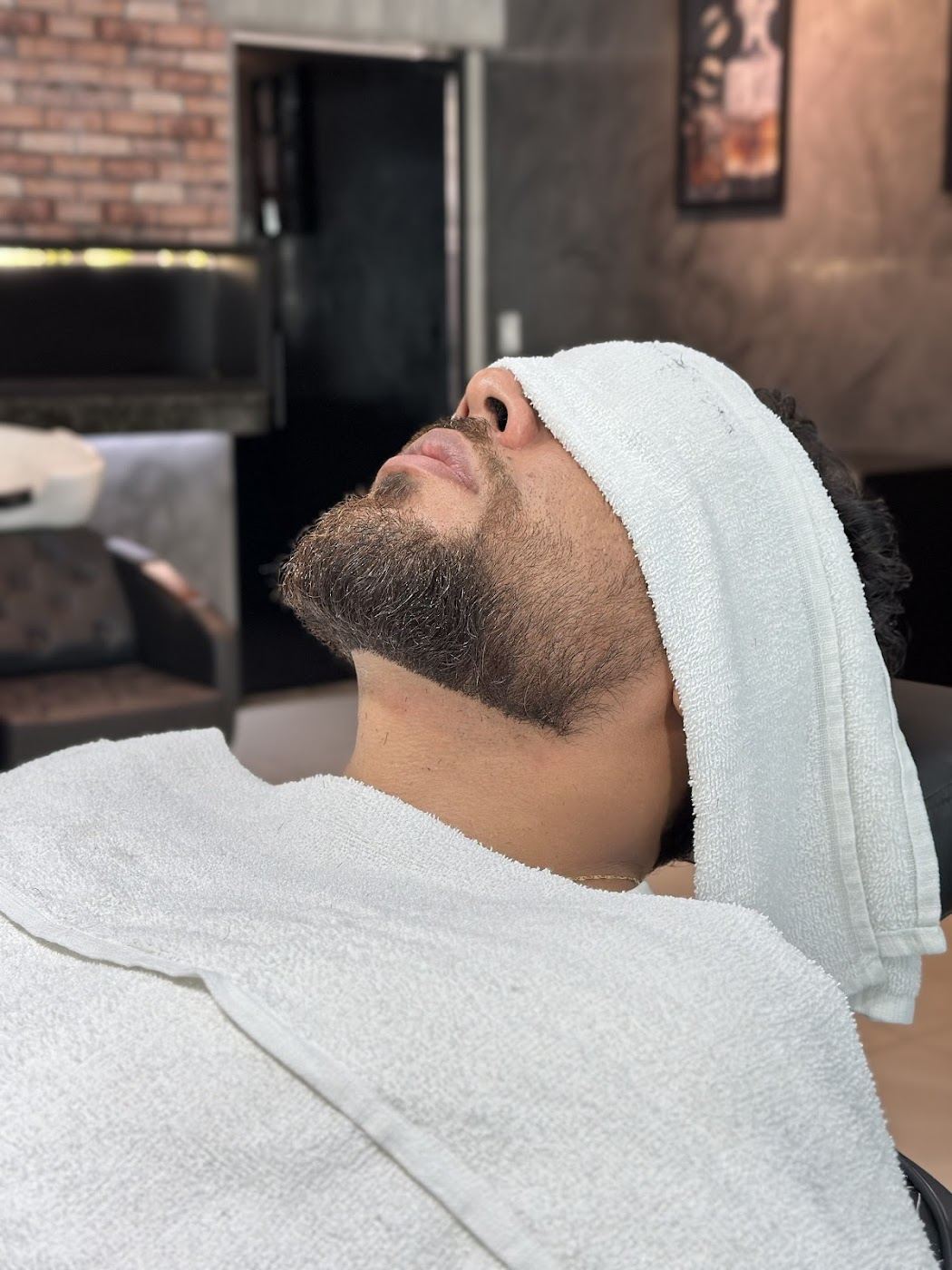Cliente da Barbearia 2P durante o ritual de toalha quente